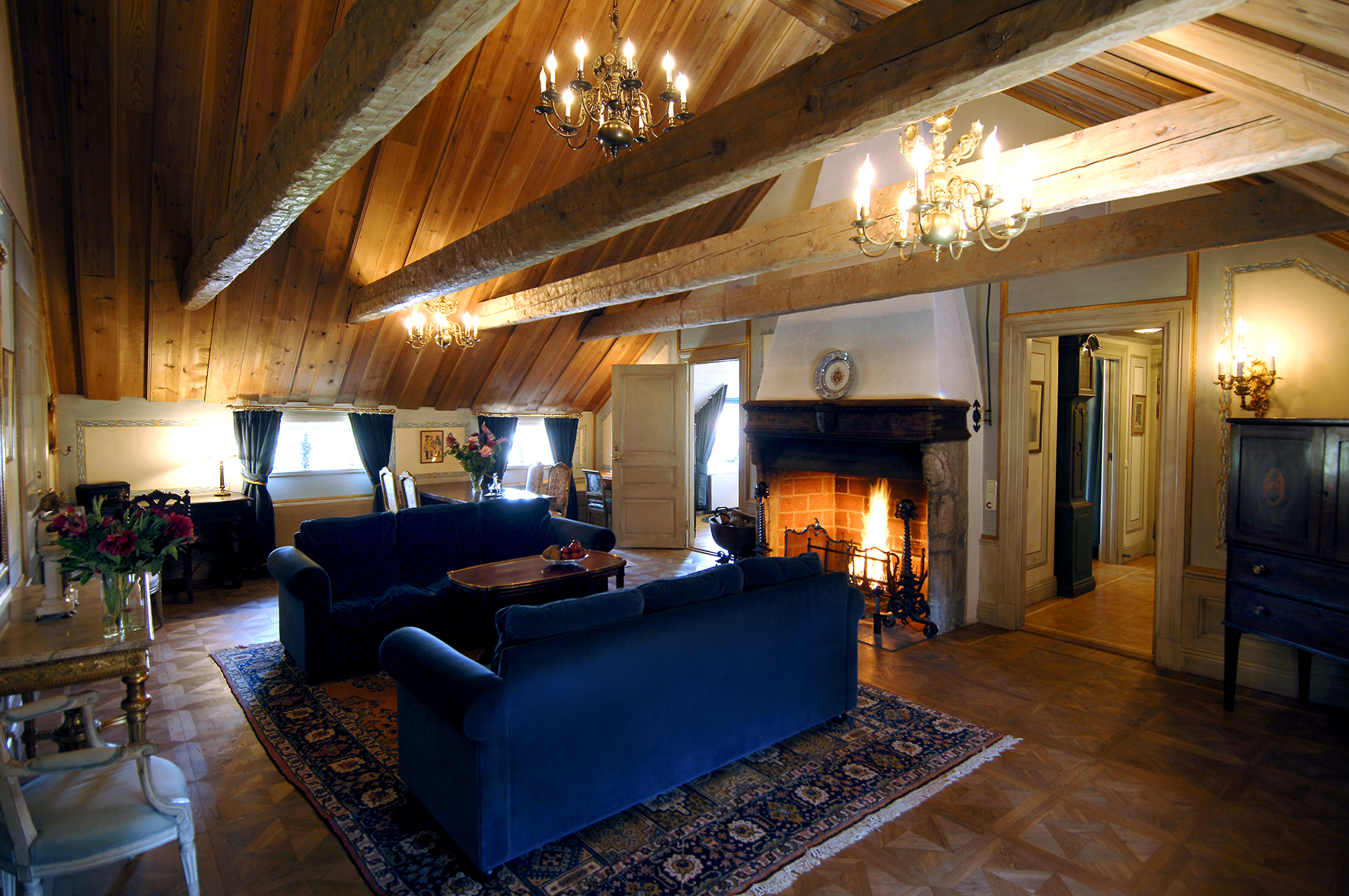En av kungasviterna på Gripsholms Värdshus med en soffgrupp framför den öppna spisen.