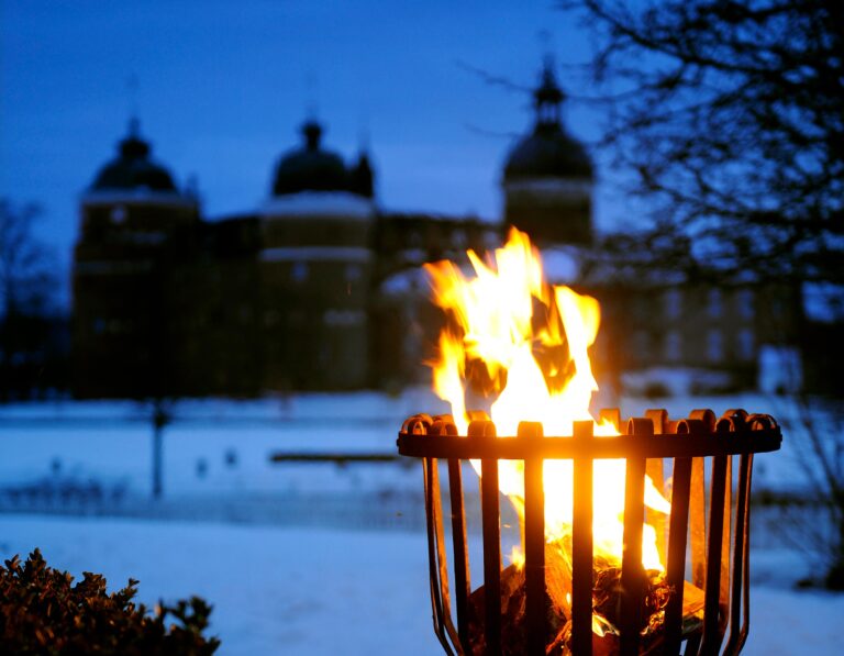 En fackla i vintermörkret med Gripsholms Slott i bakgrunden